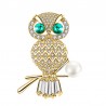 Krásna žiarivá brošňa sova je v zlatom prevedení a je posádzaná bielymi kryštálmi. Ďalším ozdobným prvkom je biela umelá perla a zeleno zafírové kryštály. Brošňa sovička je veľmi kvalitne a precízne spracovaná a bude vkusnou ozdobou na kabát, sako, bundu, sveter či šaty. Rozžiarte svoj jesenný či zimný outfit. 
