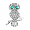 Krásna žiarivá brošňa sova je v zlatom prevedení a je posádzaná bielymi kryštálmi. Ďalším ozdobným prvkom je biela umelá perla a zeleno zafírové kryštály. Brošňa sovička je veľmi kvalitne a precízne spracovaná a bude vkusnou ozdobou na kabát, sako, bundu, sveter či šaty. Rozžiarte svoj jesenný či zimný outfit. 
